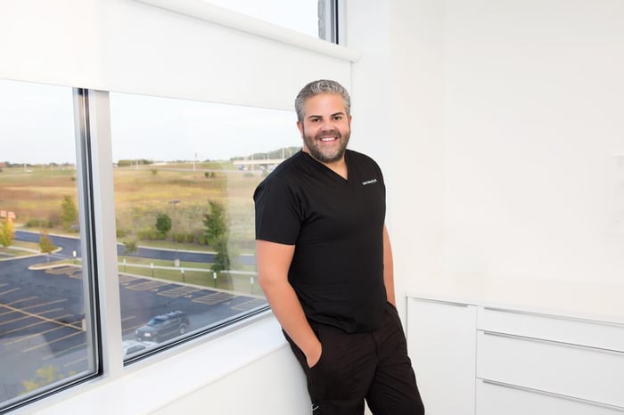 Photo of Dr. Martinez-Diaz leaning against a window in a white office.