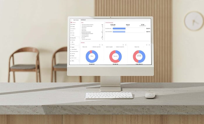 A monitor at a front desk in a dermatology waiting room shows a view of Ezderm's dashboard